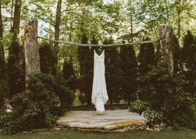 dress hanging on outdoor ceremony arch