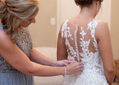 mother of the bride buttoning her dress